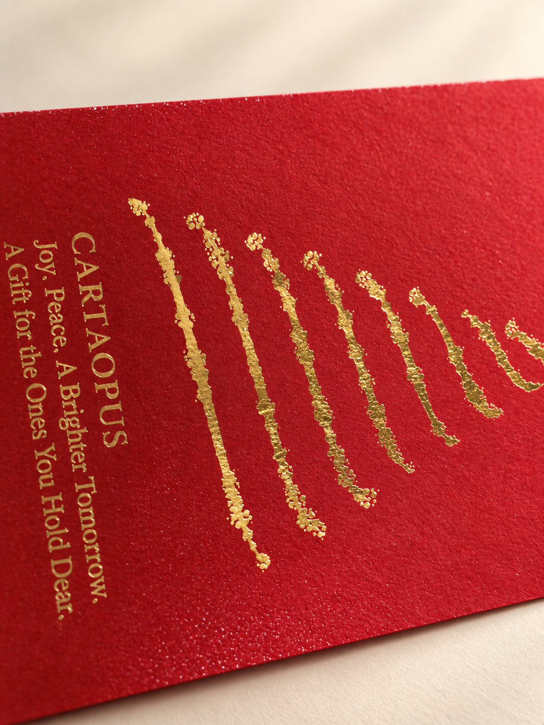Close view of gold-coloured decorative detail on the red seasonal paper packaging.