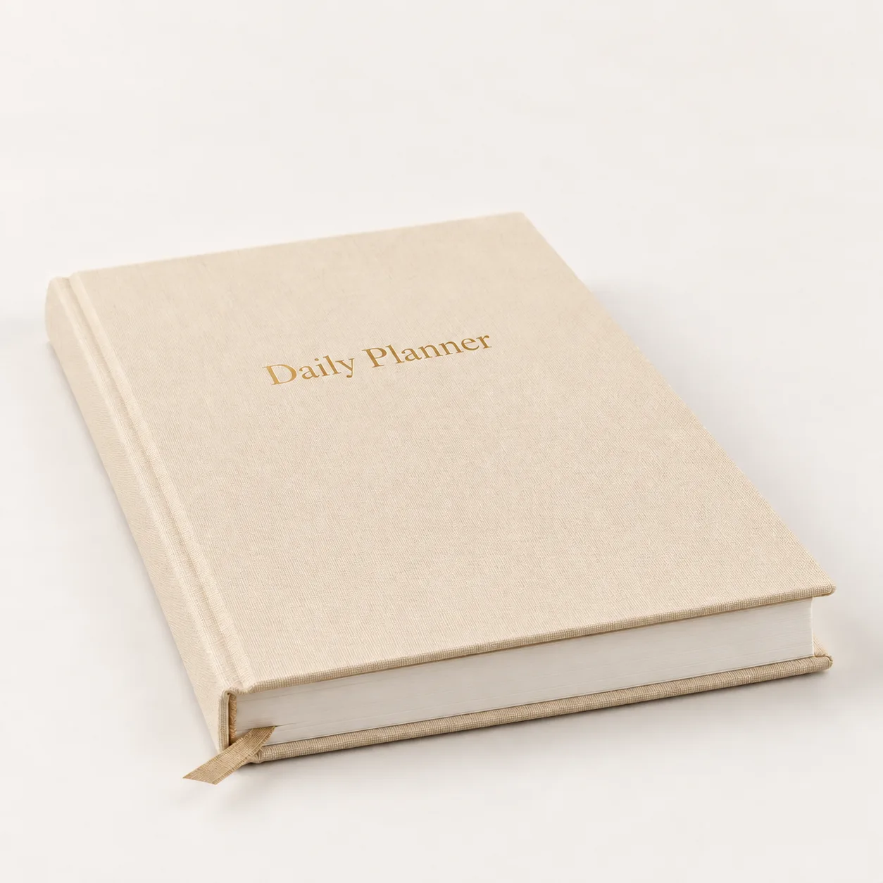 Angled front view of the beige linen Daily Planner with gold-foil title.