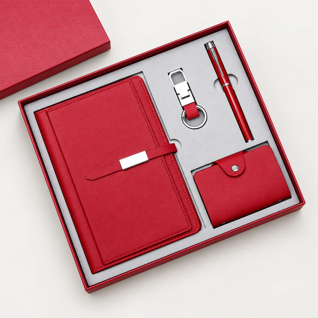 Red notebook gift set with a pen, keyring and card holder in a presentation box.