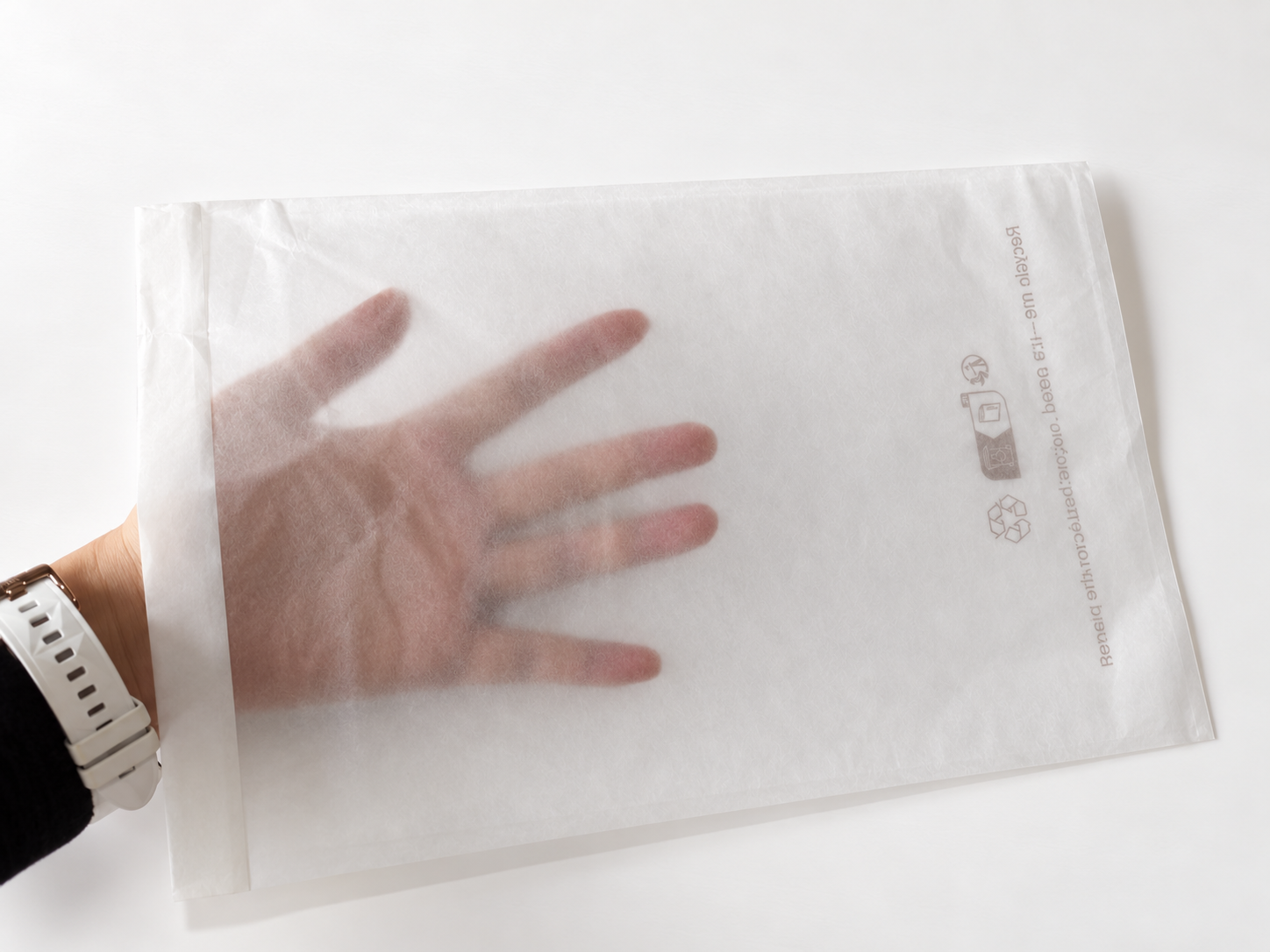 Translucent glassine paper bag shown over a hand.