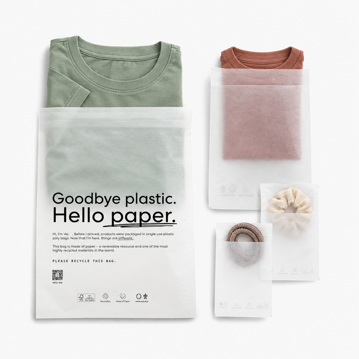 Translucent glassine paper bag shown with folded garments and small accessories.